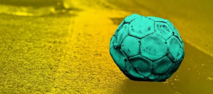 Design for Tough Start project - An old football that has too little air in it sitting on the side of the road.