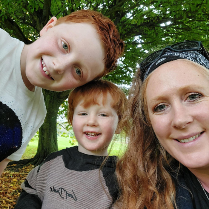 Fiona with her sons Liam and Jack all smiling with a large tree in the background