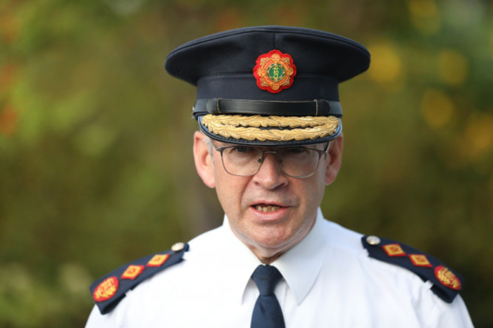 Commissioner Harris wearing glasses with a white shirt which has epaulettes - shoulder pieces - and a Garda hat.