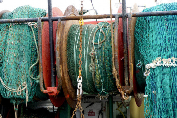 Large nets on circular reels on the back of a fishing vessel.