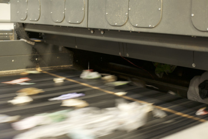 Packaging going along a conveyor belt so fast that it is blurred in the photo