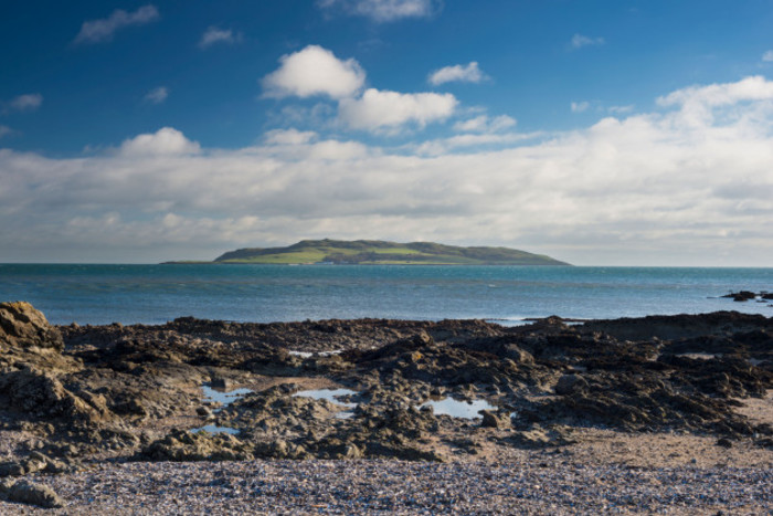 View from the seashore on the mainland across the sea to Lambay Island which is seen as a hill in the distance