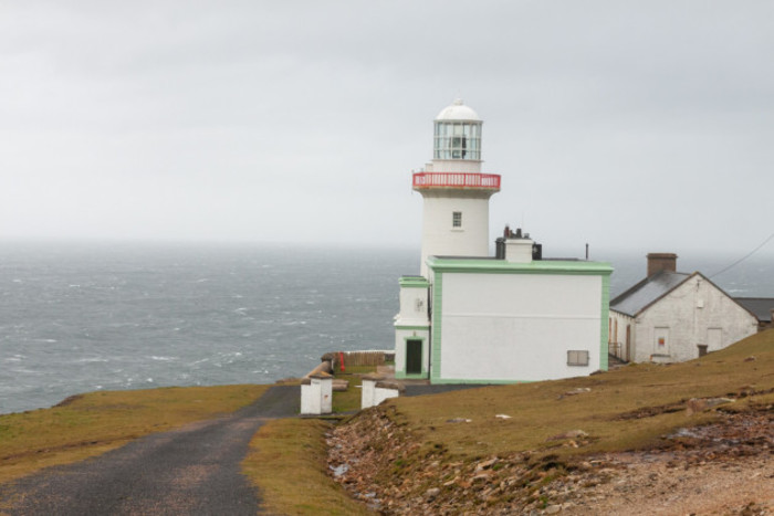 White lighthouse on Arranmore Island with the Atlantic ocean in the background