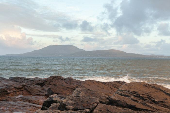 Rocks along a coast with a view of an island in the distance