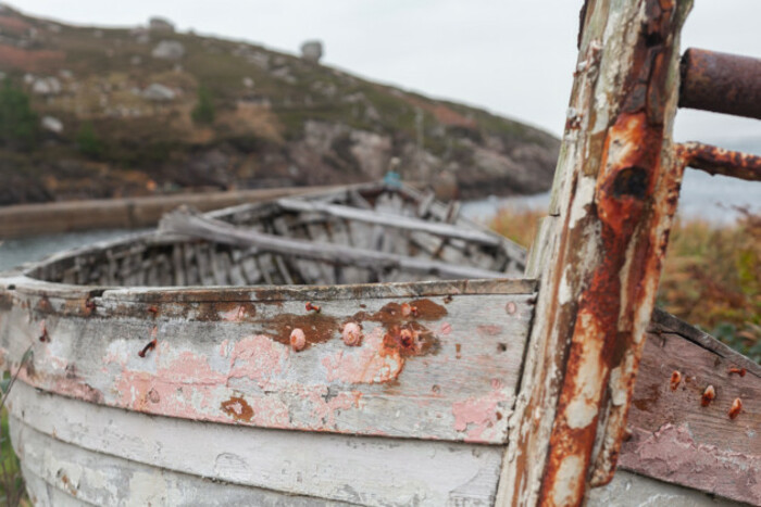 Rusting small fishing boat on the shore