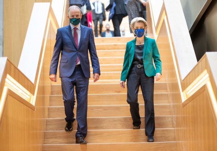 Then Taoiseach Miche&aacute;l Martin and Ursula von der Leyen - both wearing business suits and face masks - walking down a wooden stairs.