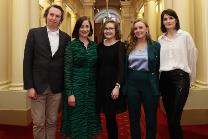 The team from Journal Media standing in a corridor which is lined with columns and paintings.