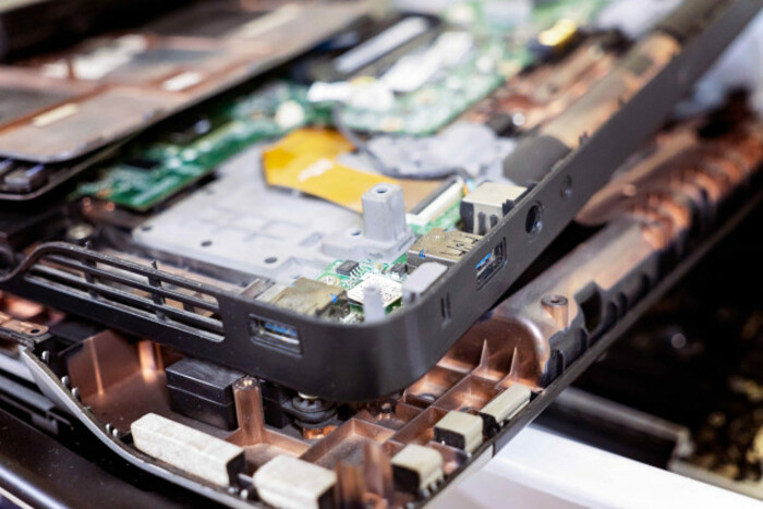 Parts of the inside of a laptop with wiring visible on top of a table