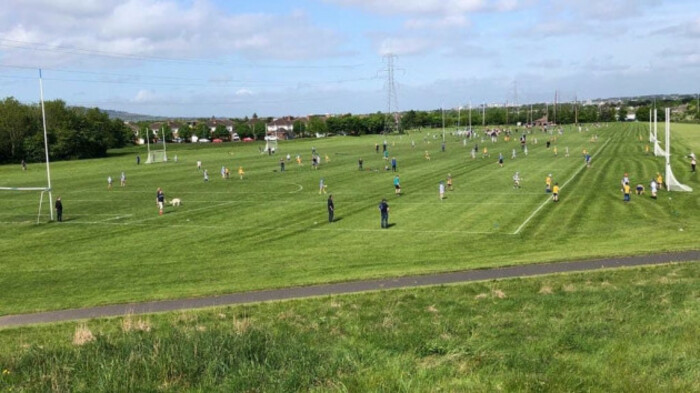 Gaelic football players running around on pitch during a match in Knocklyon Park, Dublin