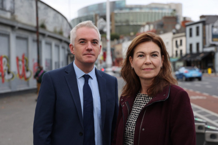 O'Sullivan wearing a suit and tie standing beside Mara on a street.